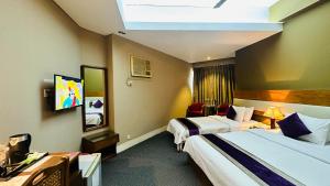 سرير أو أسرّة في غرفة في Hotel Ashrafee & Restaurant