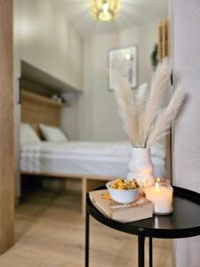 a table with a candle and a bowl of food at Pine Point Apartament with shared Pools, Jacuzzi, Sauna & Gym in Szklarska Poręba