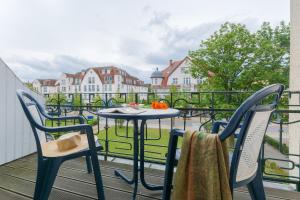 d'une table et de deux chaises sur un balcon avec vue. dans l'établissement Appartementhaus Villa Norden, à Kühlungsborn