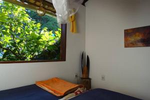a bedroom with a bed and a window at Beautiful upstairs apartment - Top view in Itacaré