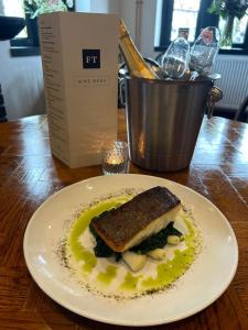 a white plate with a sandwich on a table at The Fishmongers Tavern in Sheringham