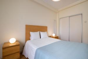 um quarto com uma cama grande e 2 mesas de cabeceira em 53 Urban Place em Ponta Delgada
