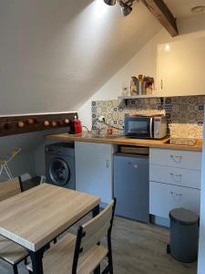 uma cozinha com uma mesa e um micro-ondas em Résidence Condorcet proche de l'aéroport d'Orly em Athis-Mons