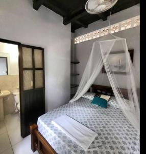 a bedroom with a bed with a mosquito net at Summer beach hotel in El Charquito