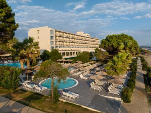 una vista aérea de un hotel con sillas y sombrillas en Ninos Grand Beach Resort, en Kastrosikia