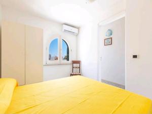 Un dormitorio con una gran cama amarilla y una ventana en Coastal Charm A Home with a View in Santa Maria di Leuca, en Leuca