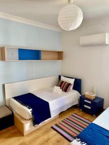 クアルテイラにあるTOM's House - T2 Sea Viewのベッドルーム1室(大型ベッド1台、青と白のベッド1台付)
