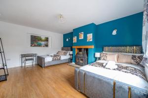 um quarto com uma cama e uma parede azul em *RD98BL* For your most relaxed & Cosy stay + Free Parking + Free Fast WiFi * em Farnley