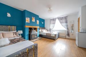 um quarto com paredes azuis, uma cama e uma lareira em *RD98BL* For your most relaxed & Cosy stay + Free Parking + Free Fast WiFi * em Farnley