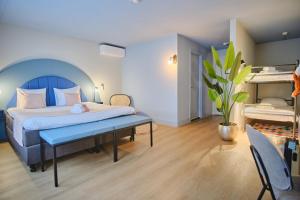um quarto com uma cama e um banco num quarto em Hotel Halbert em Groningen