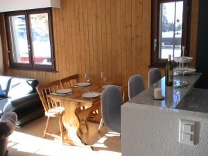 ein Esszimmer mit einem Tisch und Stühlen mit Weingläsern in der Unterkunft Relax aux Paccots : été comme hiver in Les Paccots
