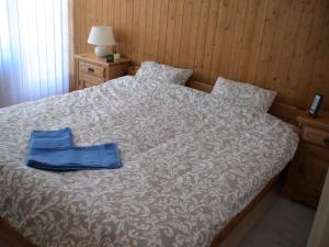ein Bett mit einer blauen Tasche darüber in der Unterkunft Relax aux Paccots : été comme hiver in Les Paccots
