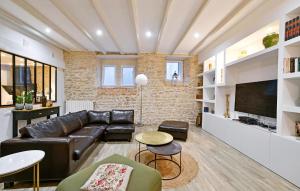 a living room with a leather couch and a tv at Gorgeous Home In Bagnols-sur-cze With Kitchen in Bagnols-sur-Cèze