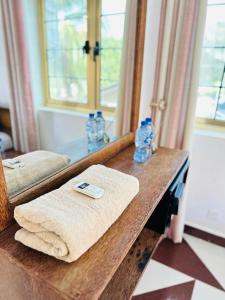 a bathroom counter with a mirror and towels on it at Airport Lux Rooms in Kiembi Samaki