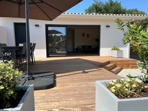 a patio with an umbrella and a table and chairs at Maison cosy à Lacanau in Lacanau