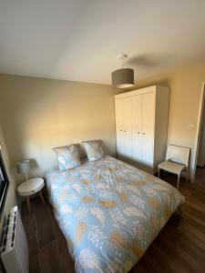 a bedroom with a bed with a blue comforter at Maison cosy à Lacanau in Lacanau