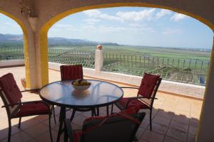 einen Tisch und Stühle auf einem Balkon mit Aussicht in der Unterkunft Los Limoneros in Pego