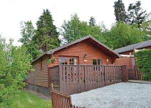 a log cabin with a wooden fence in front of it at Brookside Leisure Park in Chirk