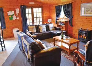 uma sala de estar com sofás de couro e uma lareira em Brookside Leisure Park em Chirk