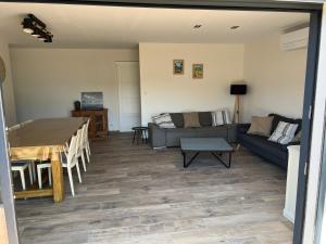 a living room with a couch and a table at Maison cosy à Lacanau in Lacanau +6 photos