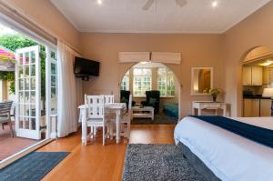 a bedroom with a bed and a table and chairs at Margate Place Guest House in Port Elizabeth