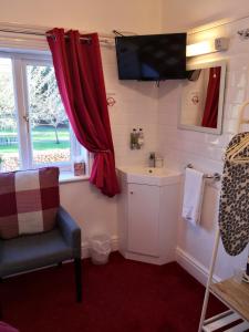 a bathroom with a sink and a tv on the wall at Ashgrove House in Stratford-upon-Avon