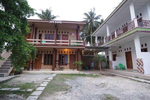 a large house with a courtyard in front of it at Sapu Nyapah Losmen Syariah Tanjung Setia in Biha