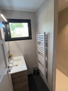 a small bathroom with a sink and a window at Maison cosy à Lacanau in Lacanau