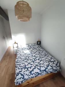 a bedroom with a bed with a blue and white comforter at La petite bascule in Orléans +1 photo