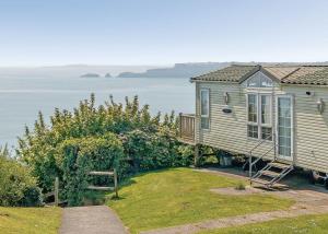 a small house with a view of the water at Meadow House Holiday Park in Amroth