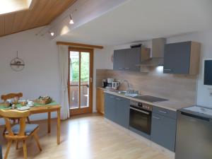 a kitchen with blue cabinets and a wooden table at Gästehaus Schörgenhofer in Waging am See