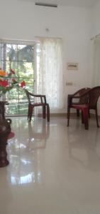 a living room with two chairs and a table at Jestine Homestay in Cochin