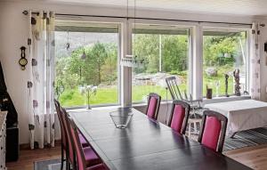 uma sala de jantar com mesa e cadeiras e uma grande janela em Awesome Home In Flekkefjord With Wifi em Flekkefjord