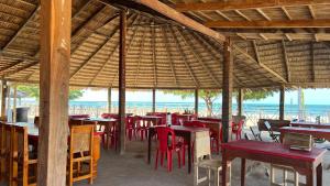 un restaurante con mesas y sillas y el océano en El Viejo Moi Hospedaje & Restaurante, en Cabo de la Vela