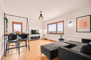 una sala de estar con un sofá y una mesa en FeWo Bodensee - See- und Bergsicht, en Friedrichshafen