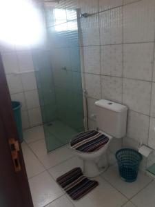 a bathroom with a toilet and a glass shower at Casa para Carnaval coruripe c/ piscina perto da praia in Coruripe