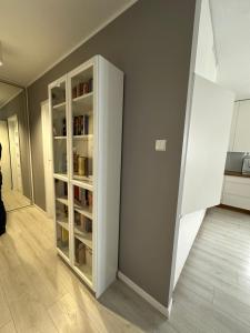 a room with a book shelf with books at Apartament Szczytno Zielona in Szczytno