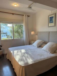 1 dormitorio con 1 cama blanca grande y ventana en Vistahermosa chalet a 100m del Buzo, en El Puerto de Santa María