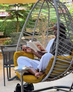 zwei Personen, die auf einem Stuhl sitzen und eine Zeitschrift lesen in der Unterkunft Mai İnci Otel in Antalya
