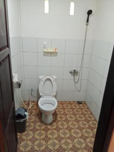 a bathroom with a white toilet in a room at Hostel Papa Tia in Rantepao
