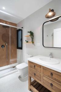 a bathroom with a sink and a toilet and a mirror at Casa de Playa Ideal para familias in Arenys de Mar