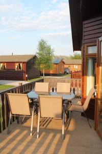 a patio with a table and chairs on a balcony at Luxury 3 bedroom lodge with free in lodge wifi in Carnforth