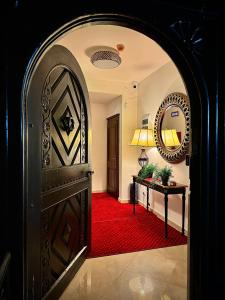 Zugang zu einem Zimmer mit einem roten Teppich und einer Tür in der Unterkunft Vila Șipot - Casa Arhitecților in Sinaia