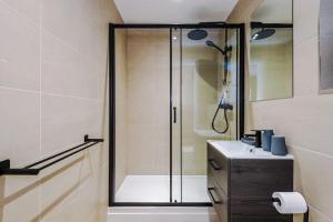 een badkamer met een glazen douche en een wastafel bij Deluxe Studio Apartment with Private Balcony in Stony Middleton