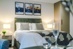 ein Schlafzimmer mit einem Bett mit vier Gemälden an der Wand in der Unterkunft Deluxe Studio Apartment with Private Balcony in Stony Middleton
