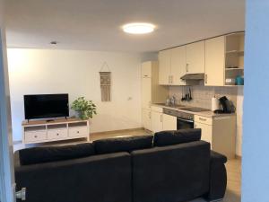 a living room with a couch and a kitchen at Ferienwohnung Am Meierhof, 50qm in Wehr