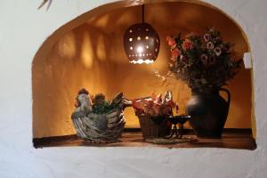 un estante con un jarrón y flores y una lámpara en Casa El Barbero 1810 en Benaocaz