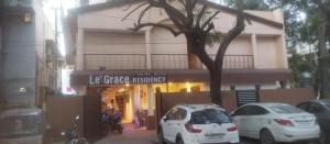 two white cars parked in front of a building at Le Grace Mansion in Madurai