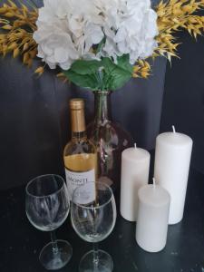 uma garrafa de vinho, dois copos e velas em Airport Apartment em Varsóvia