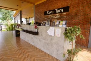 un restaurant avec un comptoir et un mur en briques dans l'établissement Kwai Tara Riverside Villas, à Sai Yok